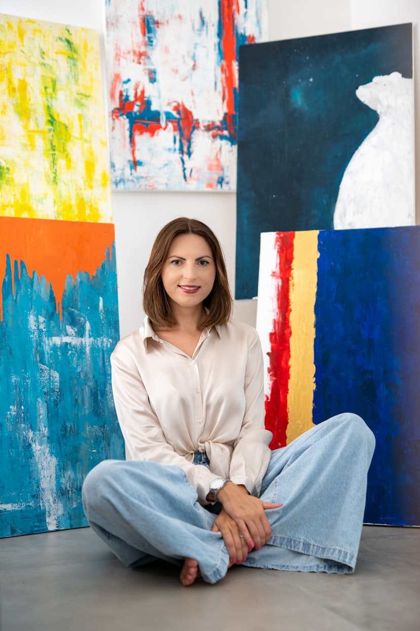 Karolina Sowa sitting surrounded by paintings